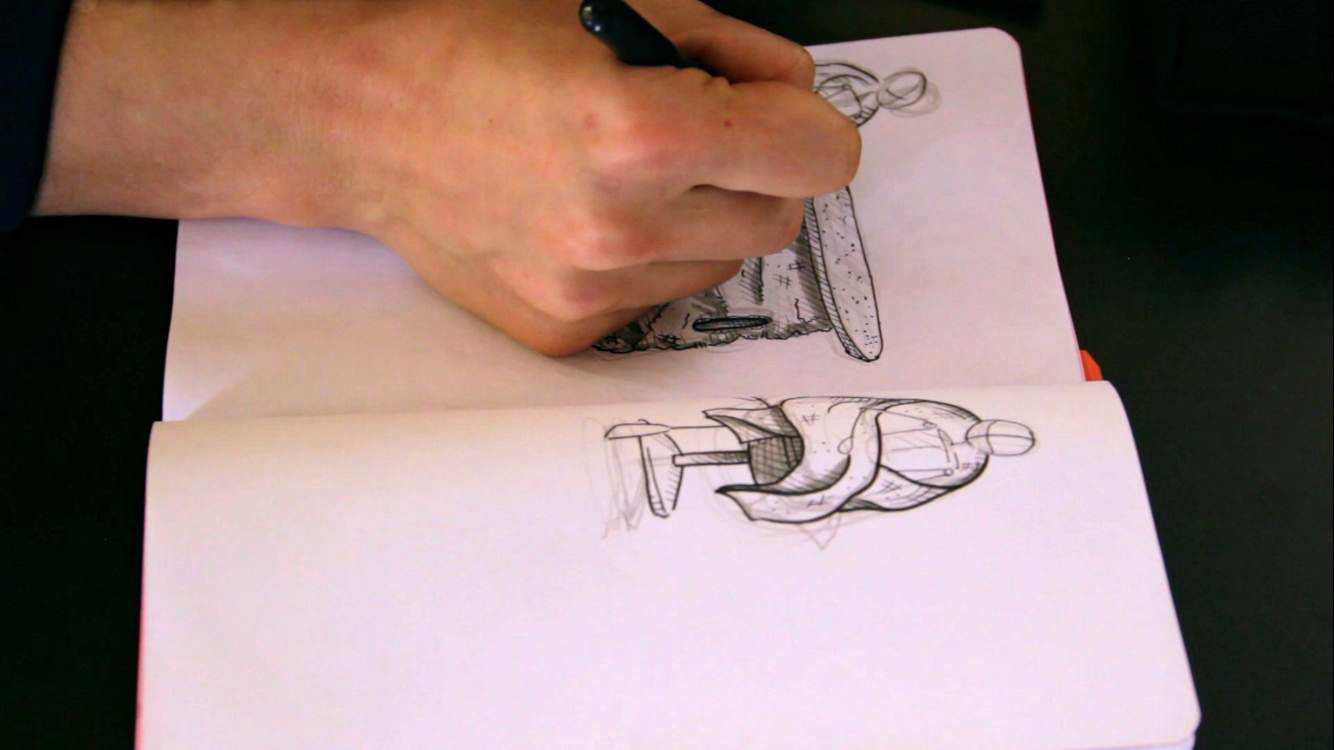 Artista disegna bozzetti di personaggi su un quaderno, mostrando creatività e abilità artistiche a mano libera.