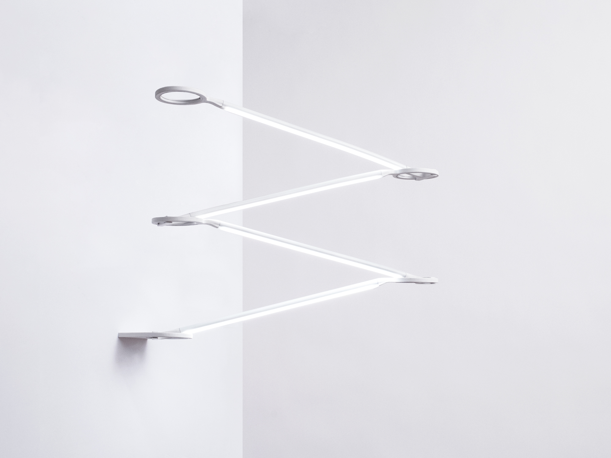 Lampada da parete moderna con bracci estensibili e design minimalista in metallo bianco montata su sfondo bianco.