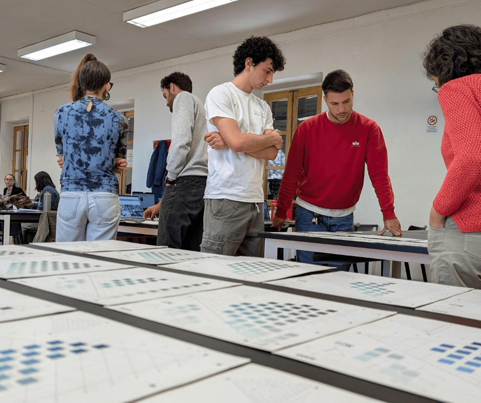Gruppo di persone discute di grafici su un tavolo in un ambiente lavorativo, concentrati e collaborativi.