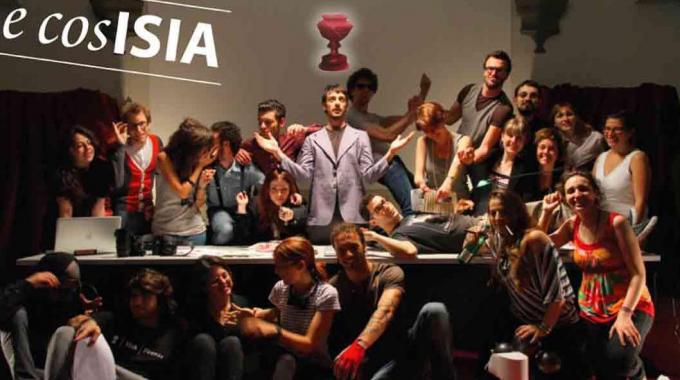 Un gruppo di persone posa in modo creativo davanti a uno striscione con la scritta ISA.