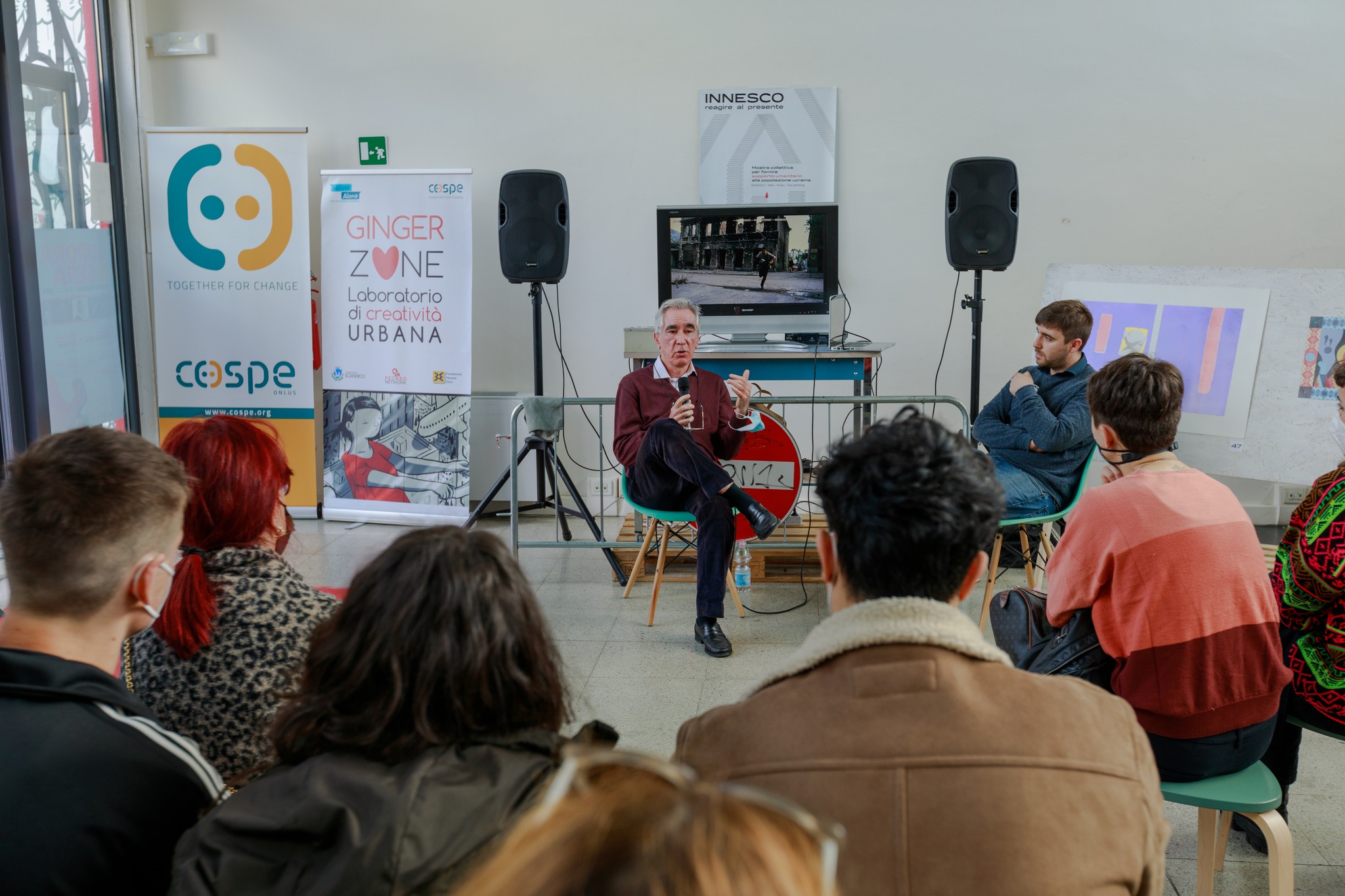 Relatore tiene una conferenza in un laboratorio creativo davanti a un gruppo di persone.