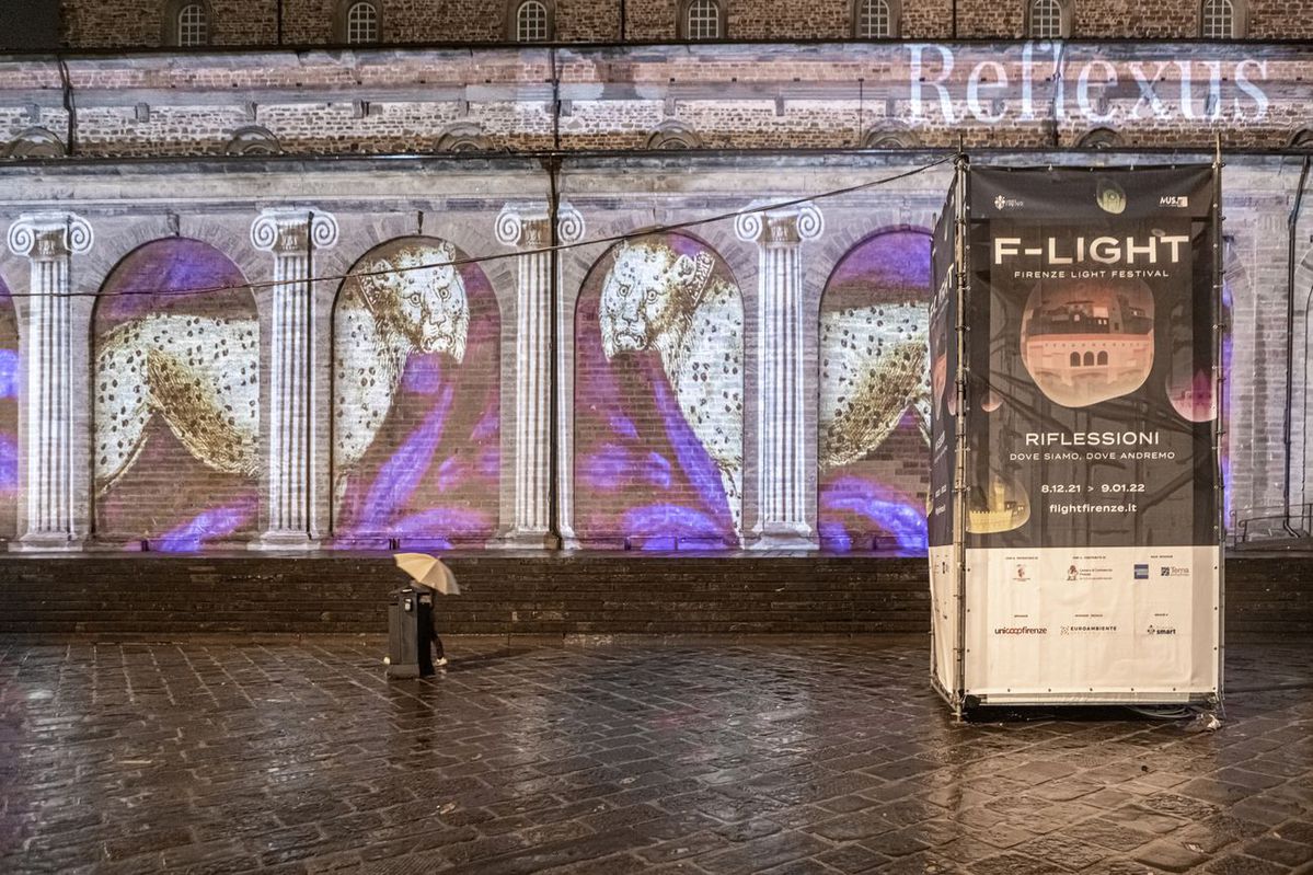 Proiezioni artistiche alla manifestazione F-Light a Firenze su una facciata storica con colonne e motivi leopardati.