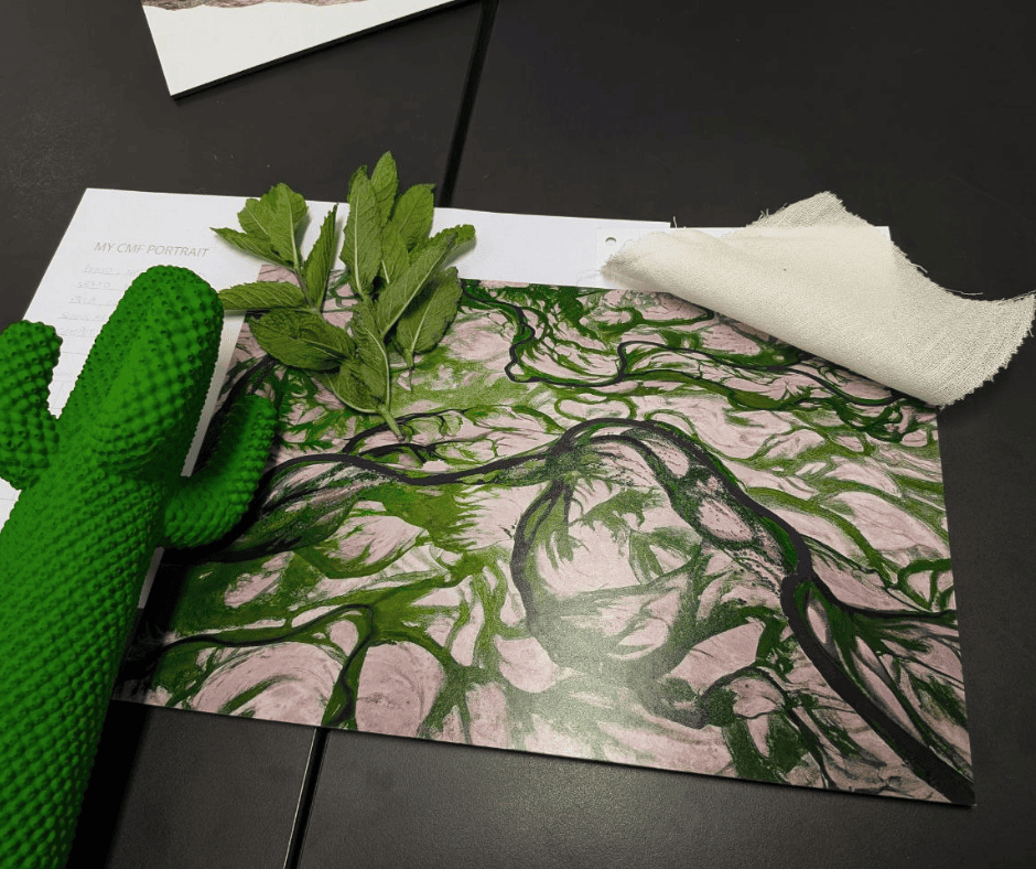 Cactus verde, foglie e tessuto grezzo su tavolo con stampa astratta in toni verdi e rosa, ispirata alla natura.