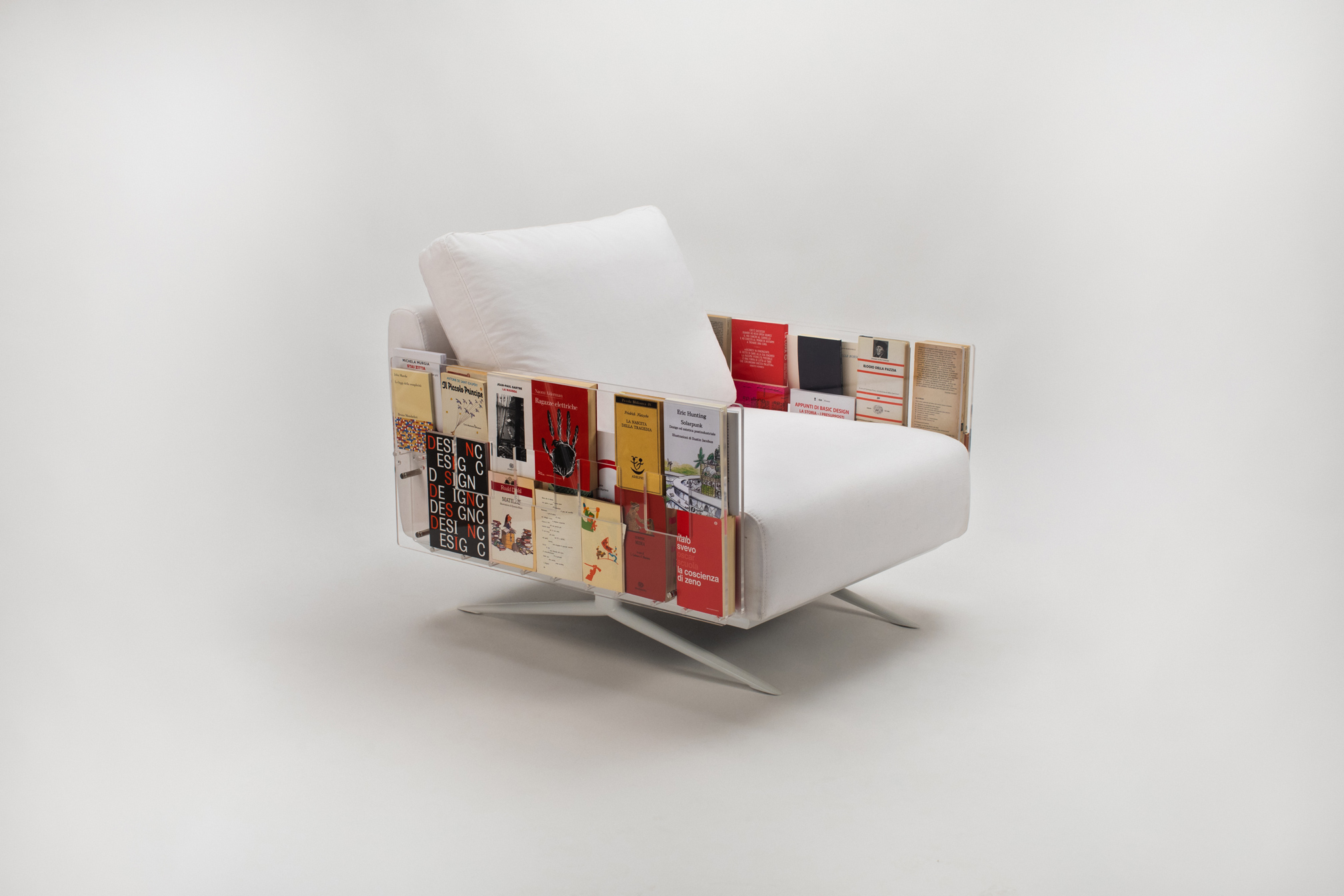 Poltrona bianca con tasche laterali che contengono libri, su sfondo neutro. Design pratico e innovativo.