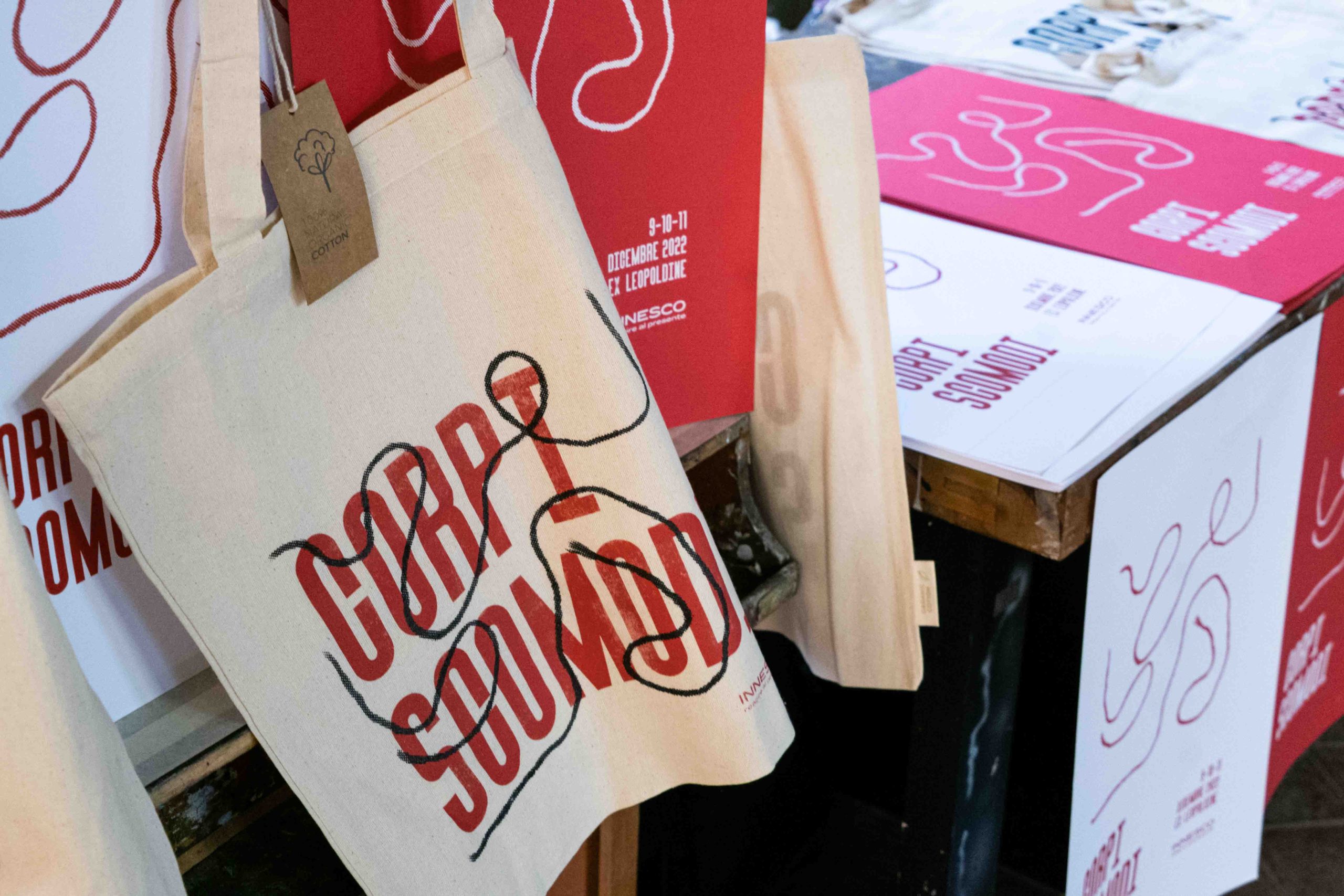 Stampa su tessuto e poster con motivo astratto e testo Corpi Scomodi, evento 9-11 dicembre 2022.