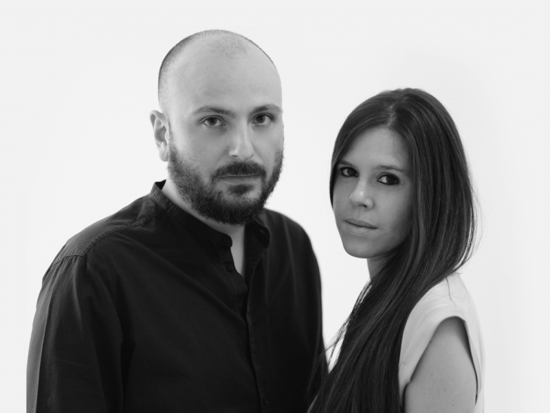 Due persone in posa, ritratto in bianco e nero con sfondo chiaro.