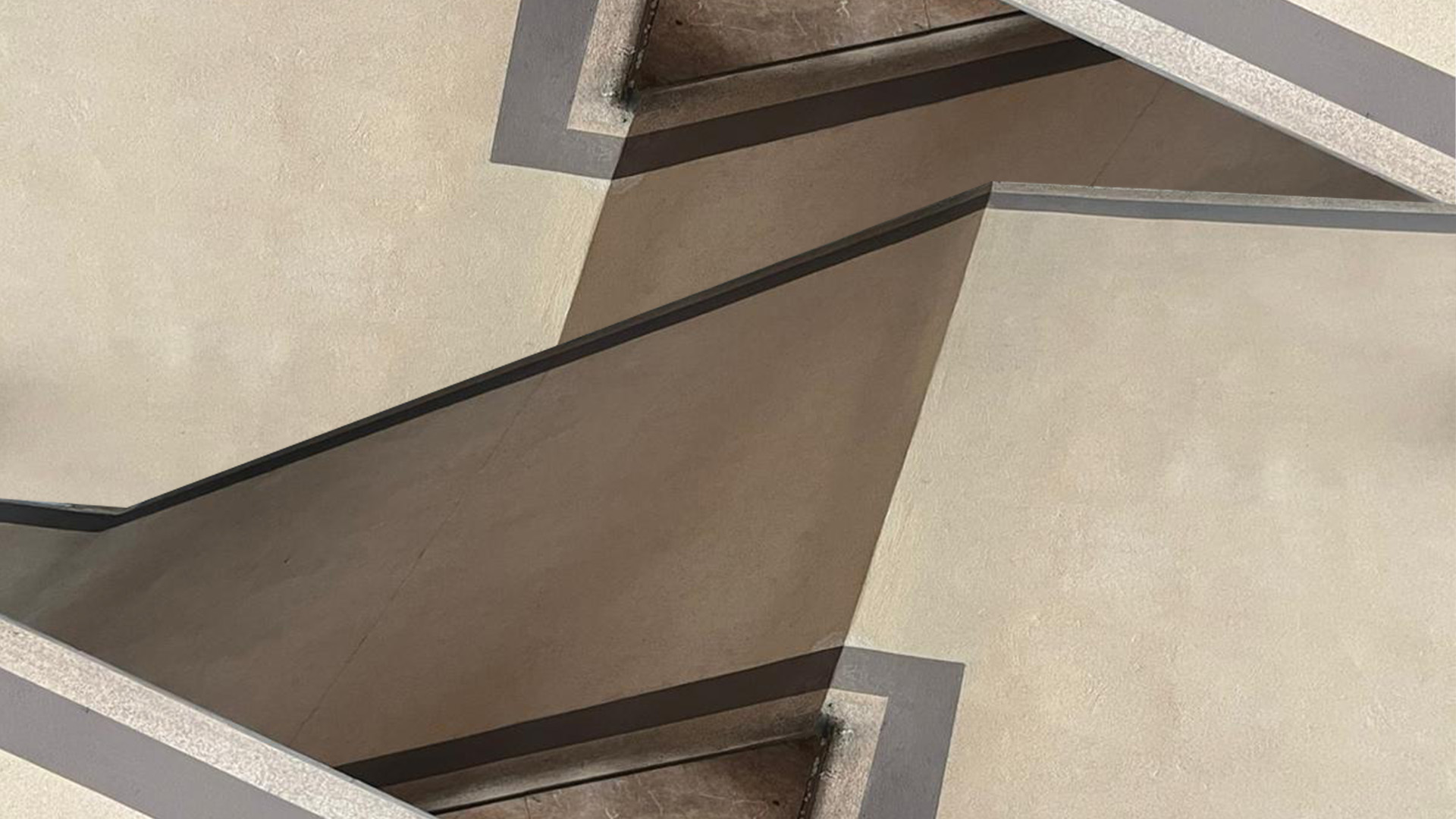 Forme geometriche e angoli moderni di un'architettura minimalista con ombre marcate e linee essenziali.