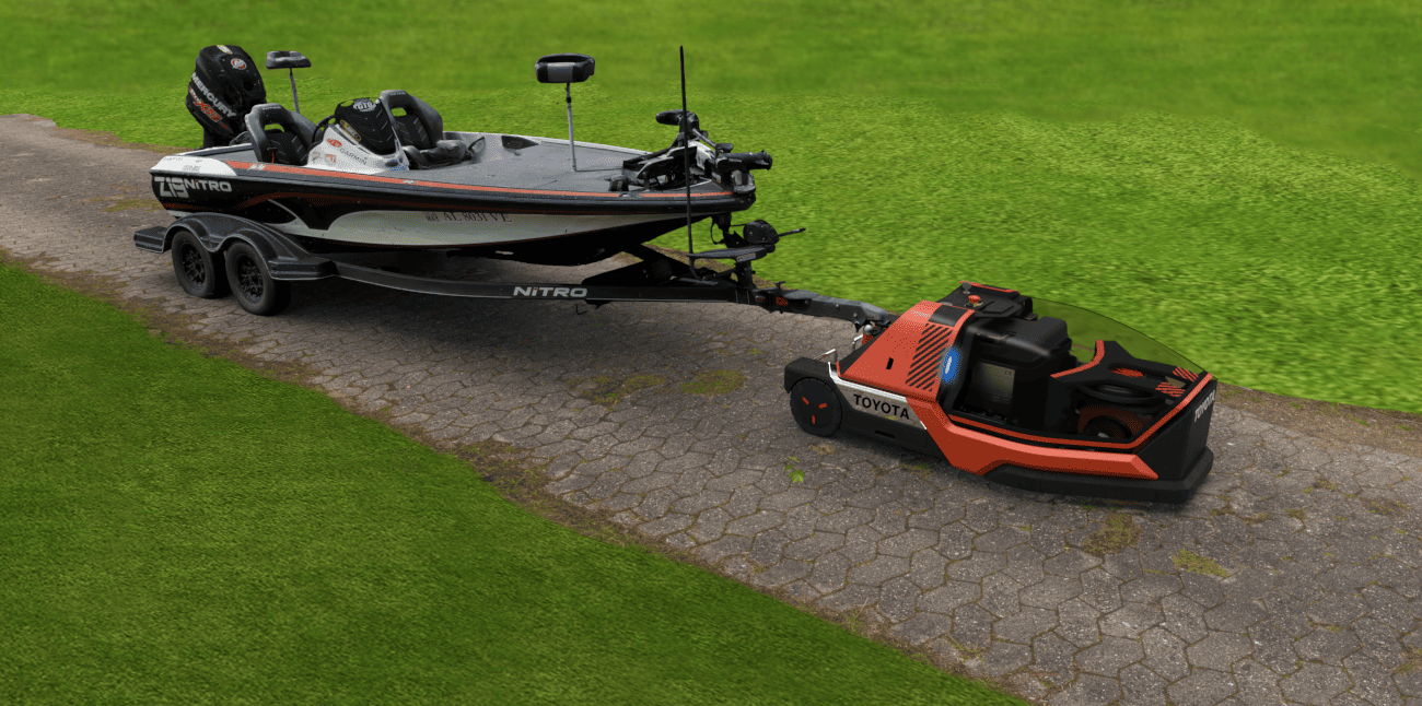 Robot Toyota traina barca su sentiero in pietra, circondato da erba verde. Innovazione nel trasporto nautico.