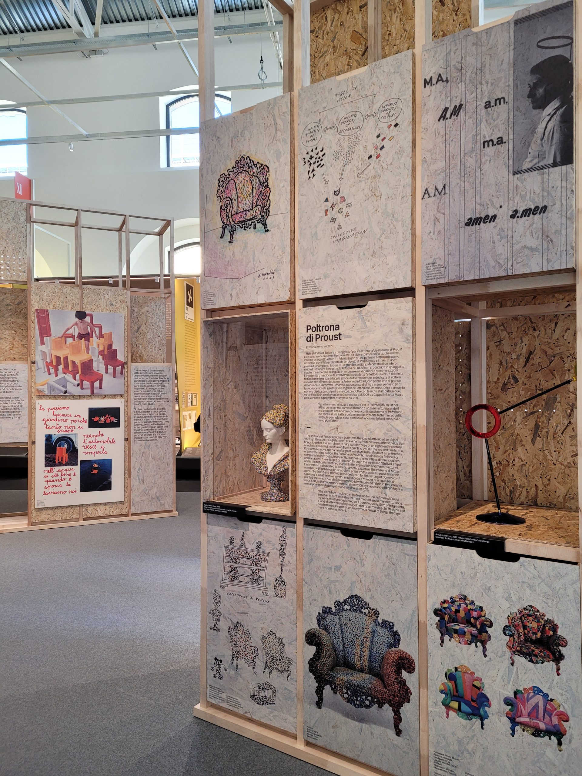 Spazio espositivo con pannelli decorativi e opere artistiche, tra cui la Poltrona di Proust e una scultura busto.