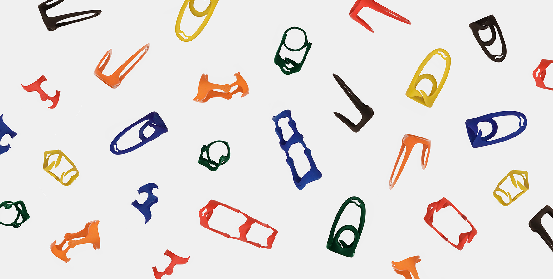 Forme geometriche colorate in plastica sparse su sfondo bianco minimalista.