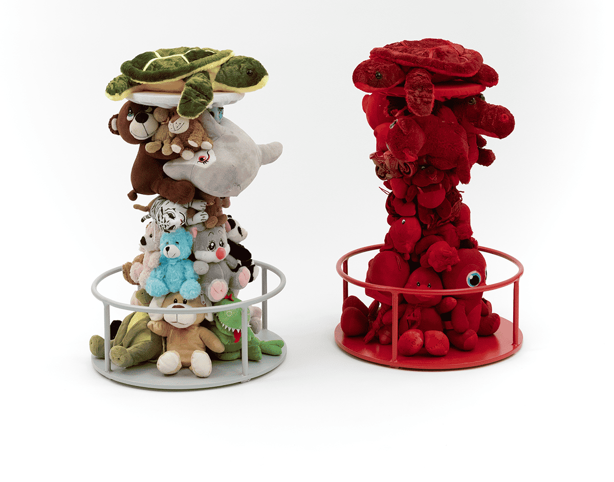 Due torri di peluche colorati impilati in strutture rotonde, su sfondo bianco.