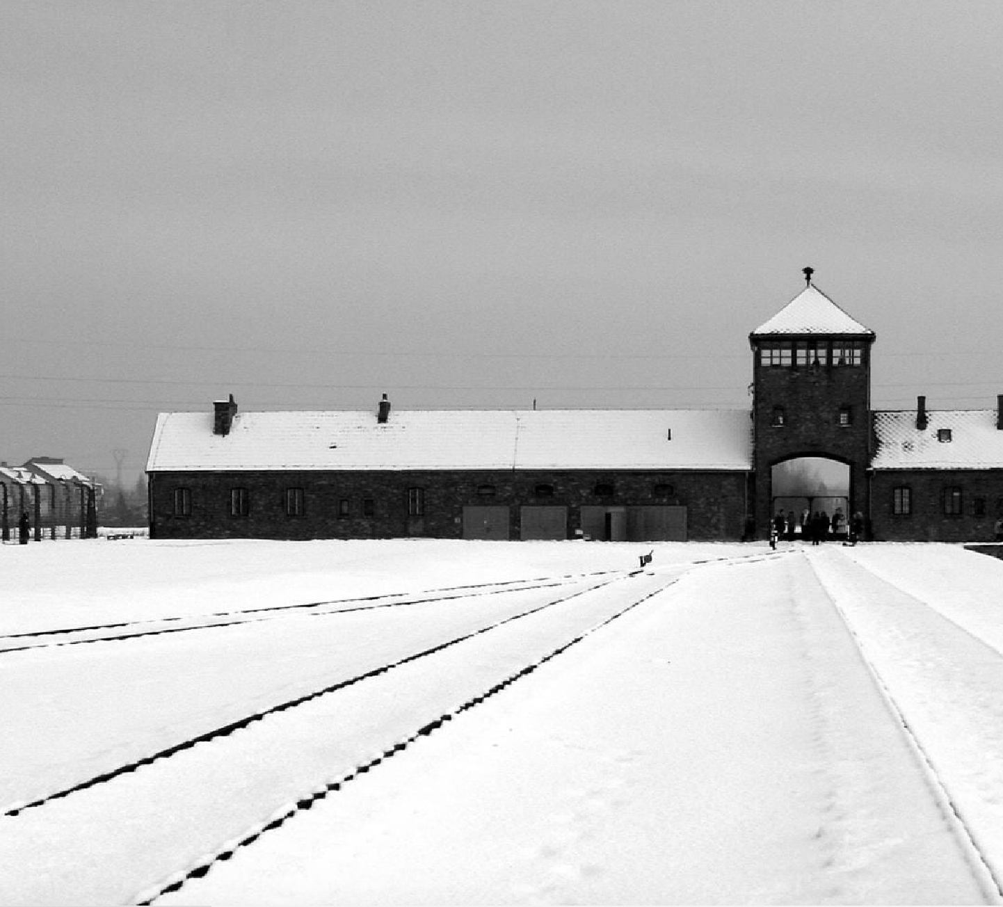 Ingresso di Auschwitz-Birkenau in inverno, binari coperti di neve, cielo grigio. Memoriale dell'Olocausto.