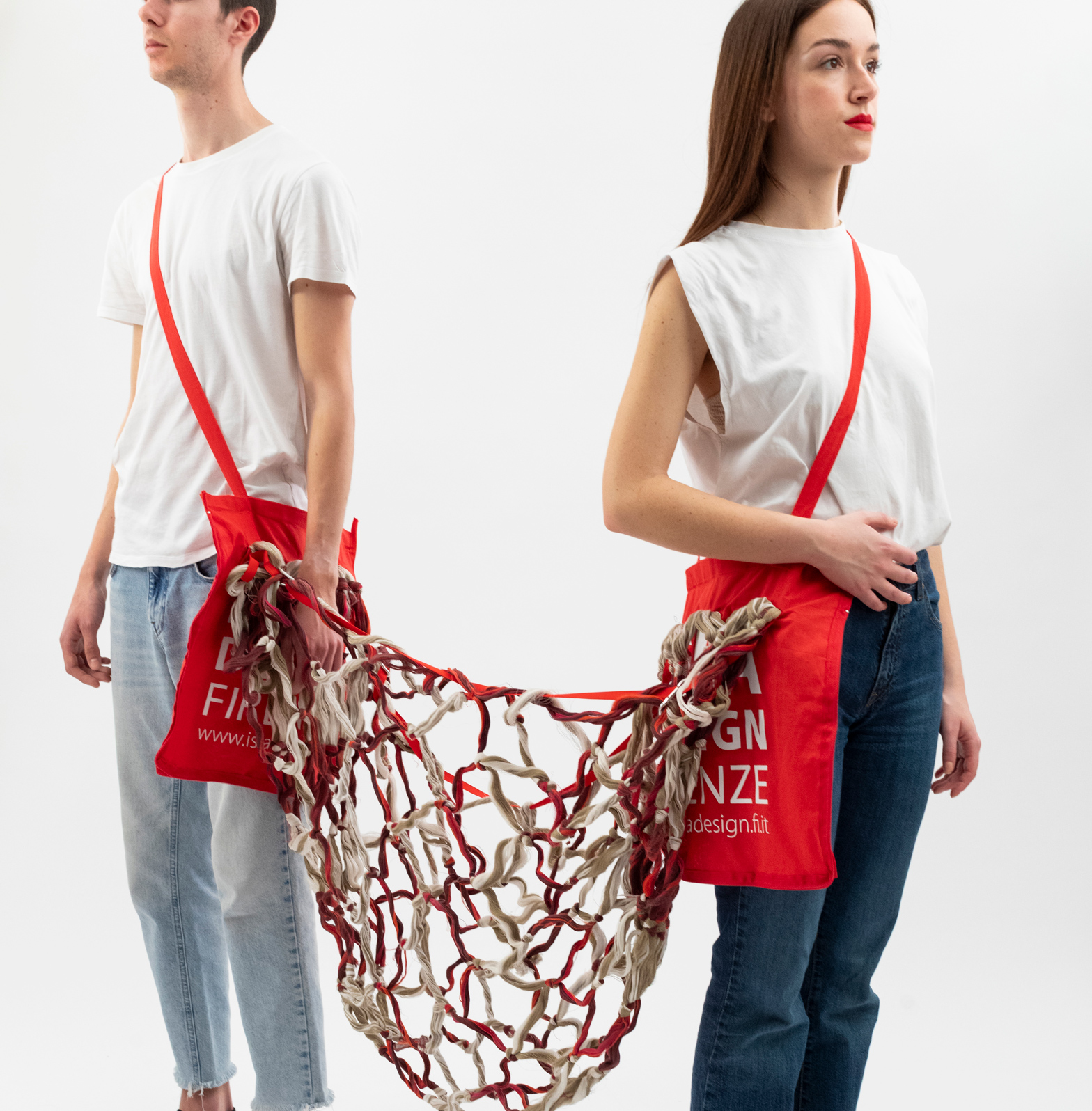 Due persone con borse rosse collegate da rete intrecciata, indossano jeans e magliette bianche su sfondo bianco.