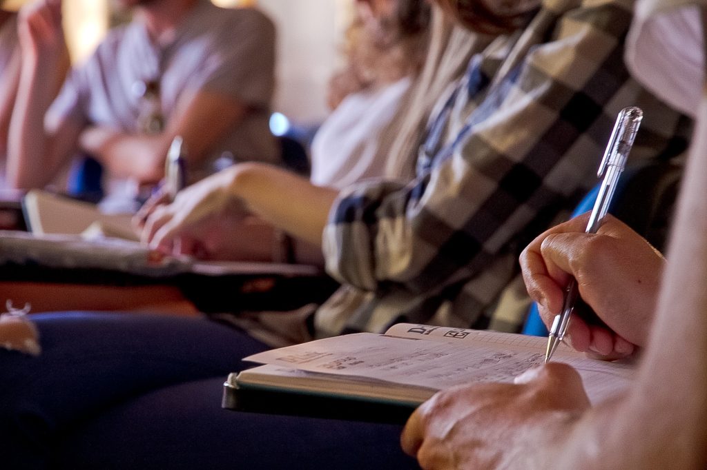 Foto di persone che prendono appunti durante la summer school "La Cura" organizzata in ISIA Firenze