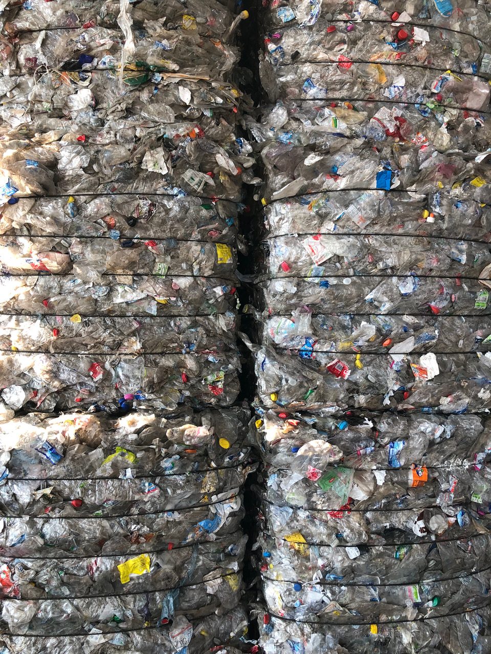 Balle di plastica compattate per il riciclaggio, mostrate in pila ordinata, pronte per il trattamento sostenibile.